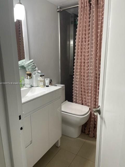 bathroom with toilet, tile flooring, and vanity