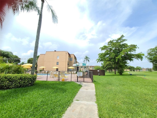 view of property's community featuring a swimming pool and a yard