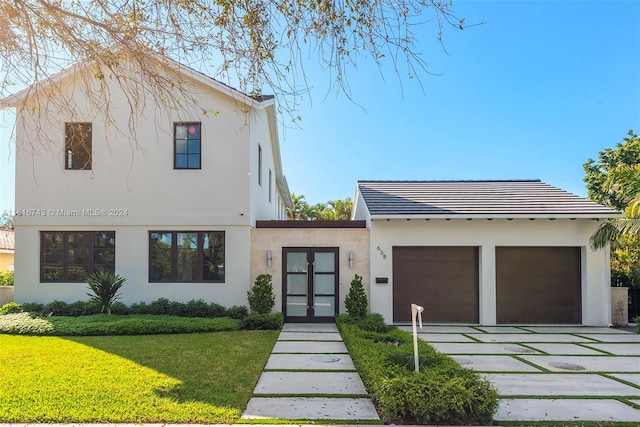 view of front of property with a garage and a front lawn