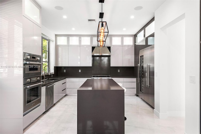 kitchen featuring white cabinets, stainless steel appliances, pendant lighting, a kitchen island, and tasteful backsplash