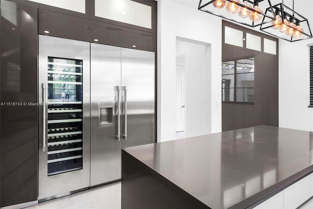 kitchen featuring pendant lighting, dark brown cabinetry, white cabinetry, and built in refrigerator