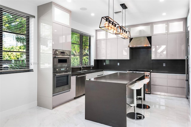 kitchen featuring appliances with stainless steel finishes, a center island, wall chimney exhaust hood, and white cabinetry