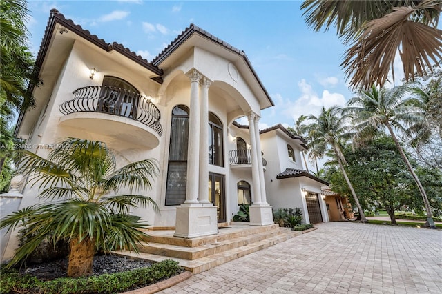 view of front of property featuring a balcony and a garage