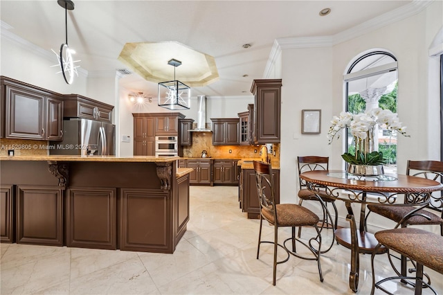 kitchen with stainless steel fridge, crown molding, backsplash, wall chimney exhaust hood, and decorative light fixtures