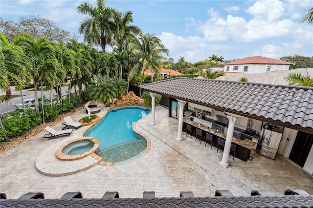 view of swimming pool with an in ground hot tub and a patio