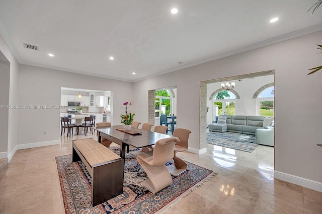 dining room featuring crown molding, plenty of natural light, and a chandelier