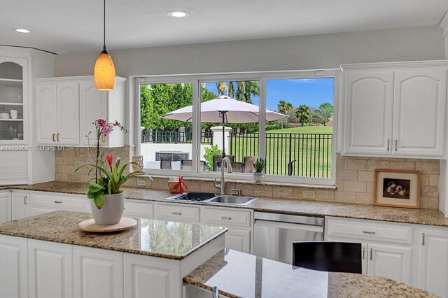 kitchen featuring a kitchen island, decorative light fixtures, white cabinets, backsplash, and plenty of natural light