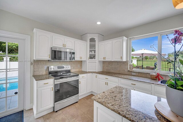 kitchen featuring sink, dishwasher, white cabinetry, decorative backsplash, and decorative light fixtures