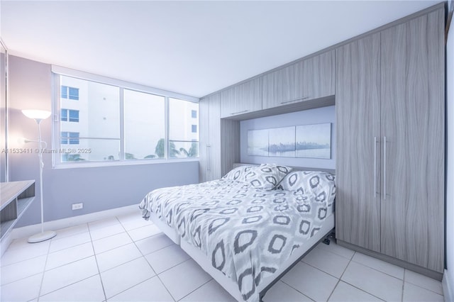 bedroom featuring light tile patterned floors and baseboards