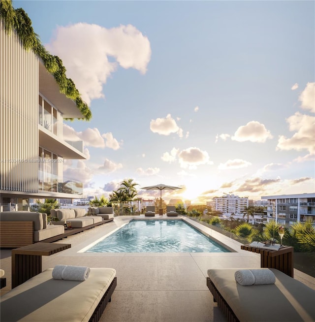 pool at dusk featuring an outdoor living space and a patio