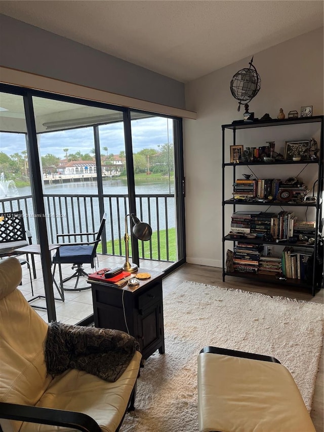 living room featuring hardwood / wood-style flooring and a water view