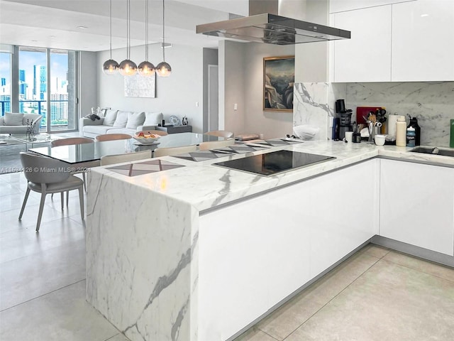 kitchen featuring ventilation hood, hanging light fixtures, and white cabinets