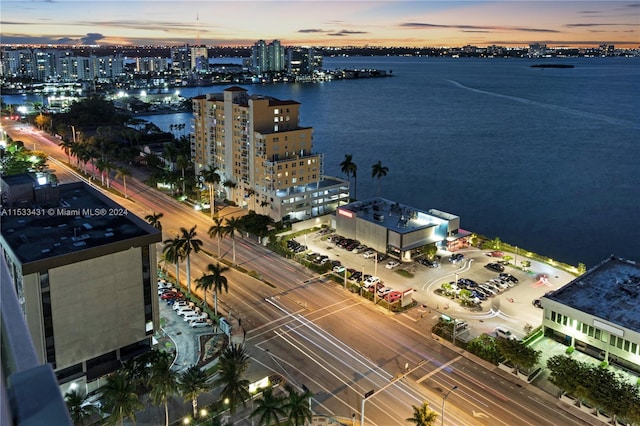 aerial view at dusk featuring a water view