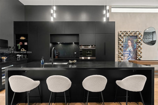 kitchen featuring a center island, a kitchen bar, sink, and light hardwood / wood-style flooring