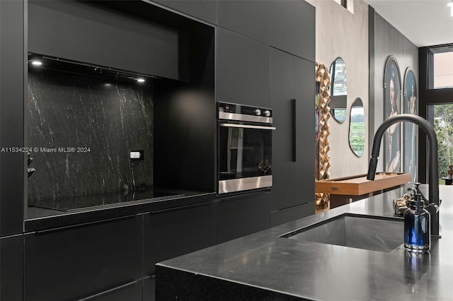 details with stainless steel oven, black electric cooktop, and sink