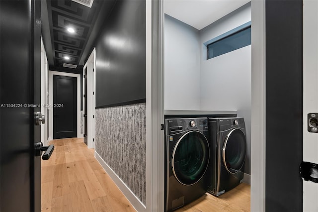 laundry room featuring washer and dryer and light hardwood / wood-style floors