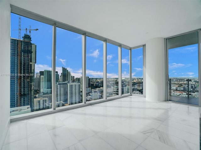 spare room featuring light tile floors and expansive windows