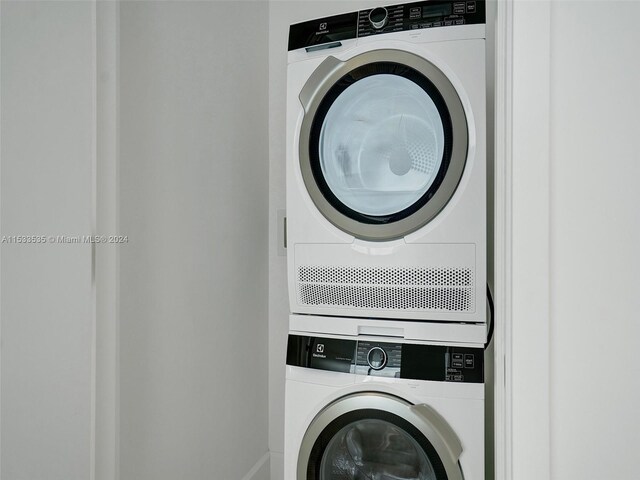 clothes washing area featuring stacked washer / dryer