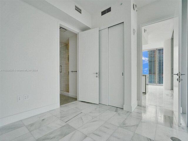 unfurnished bedroom featuring a closet and light tile flooring