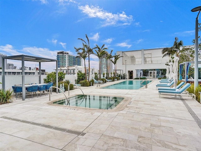 view of pool featuring a community hot tub and a patio