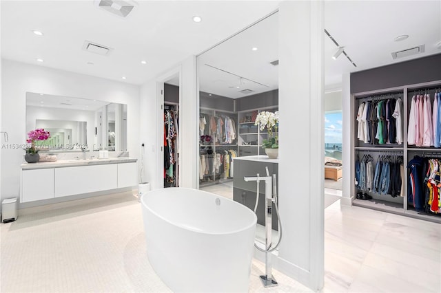 bathroom with vanity and a tub to relax in