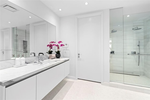 bathroom featuring tile patterned flooring, a shower with shower door, and vanity