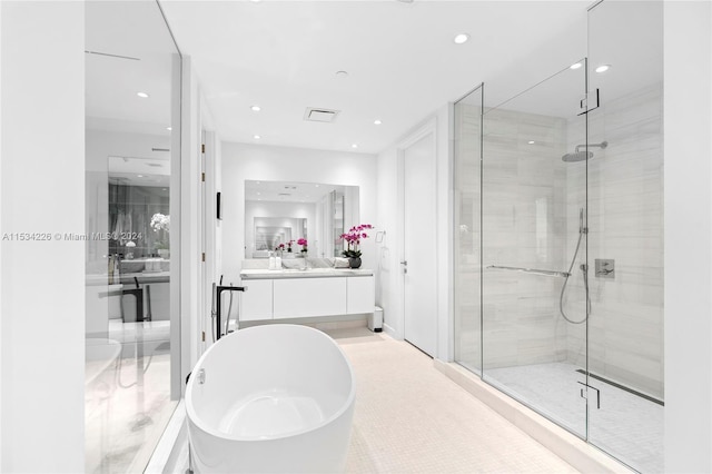 bathroom featuring vanity and separate shower and tub