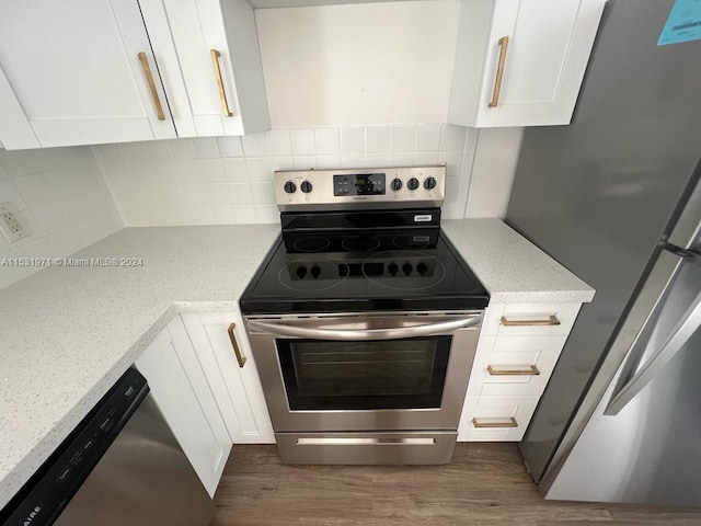 kitchen featuring backsplash, dark hardwood / wood-style floors, stainless steel appliances, and white cabinets