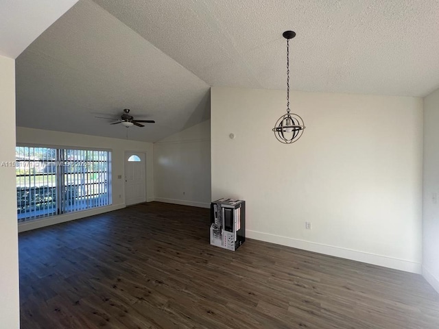 unfurnished room with a textured ceiling, dark hardwood / wood-style flooring, ceiling fan with notable chandelier, and lofted ceiling