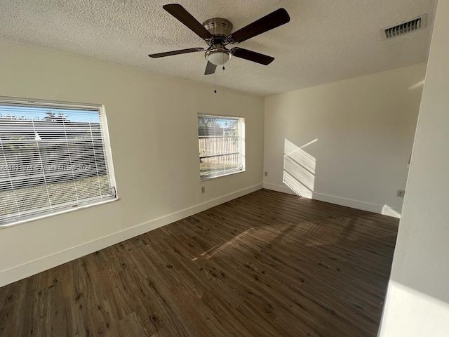 empty room with dark hardwood / wood-style floors, a textured ceiling, and ceiling fan