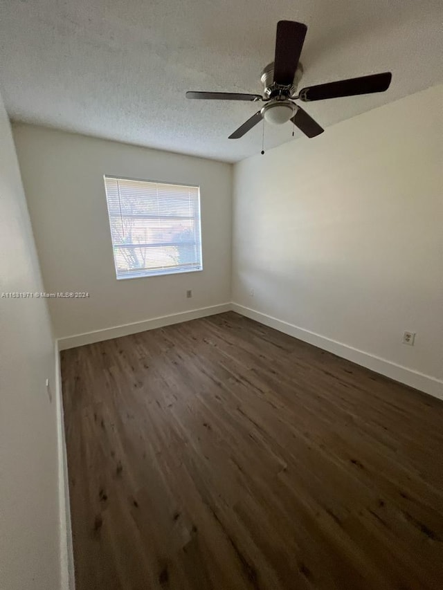 spare room featuring ceiling fan, a textured ceiling, and dark wood-type flooring