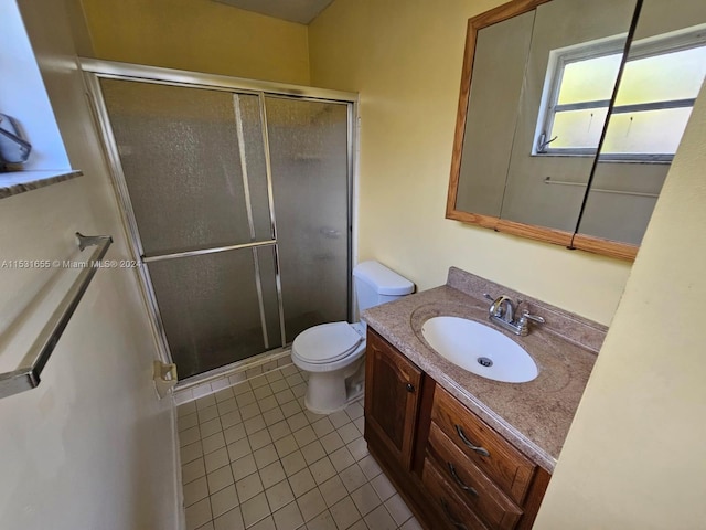 bathroom featuring tile floors, large vanity, a shower with shower door, and toilet