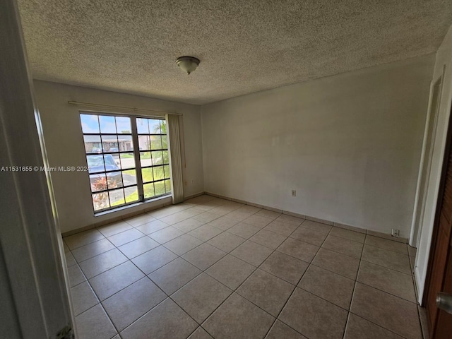 tiled spare room with a textured ceiling