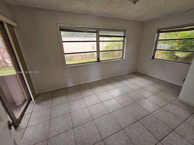 spare room with light tile floors and a wealth of natural light