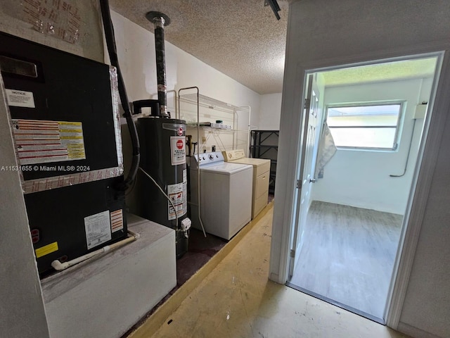 utility room with water heater, washer and clothes dryer, and heating utilities