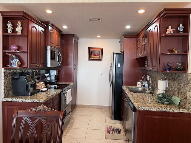 kitchen featuring tasteful backsplash, stainless steel appliances, light tile flooring, and light stone counters