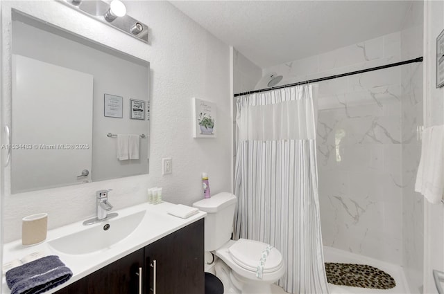 bathroom with toilet, vanity, a textured ceiling, and walk in shower