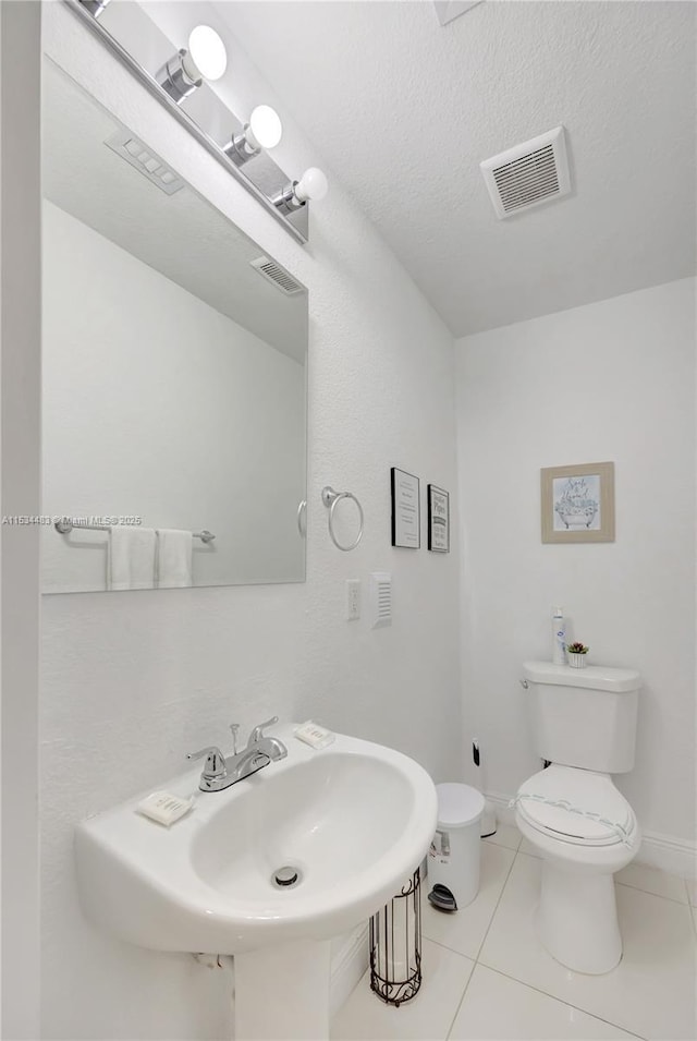 bathroom featuring sink, tile patterned flooring, a textured ceiling, and toilet