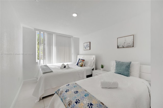 tiled bedroom featuring a wall of windows