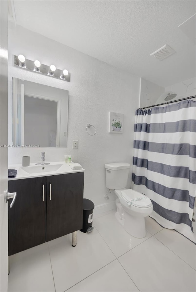 bathroom with tile patterned floors, a textured ceiling, vanity, toilet, and curtained shower