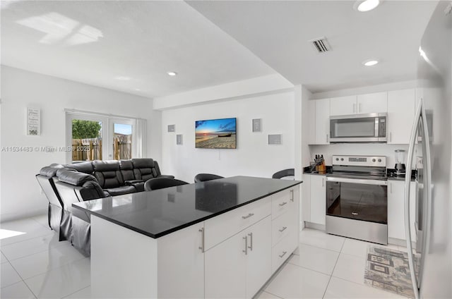 kitchen featuring white cabinetry, a center island, french doors, light tile patterned floors, and appliances with stainless steel finishes