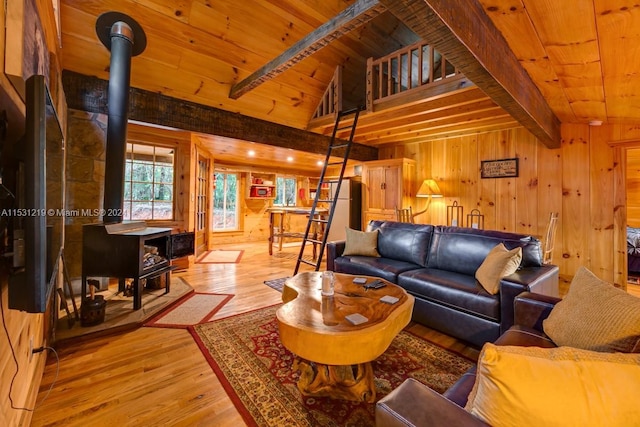 living room featuring light wood-type flooring, beam ceiling, high vaulted ceiling, wooden ceiling, and wood walls