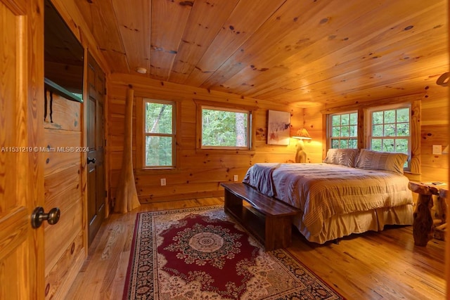 bedroom featuring light wood-type flooring, multiple windows, and wooden ceiling