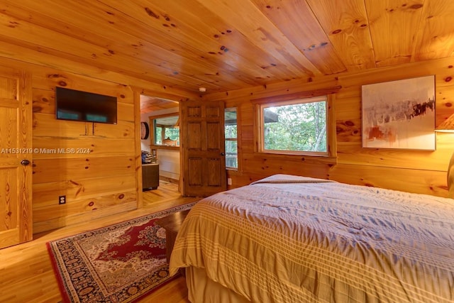 bedroom with wooden walls, wood ceiling, and light wood-type flooring