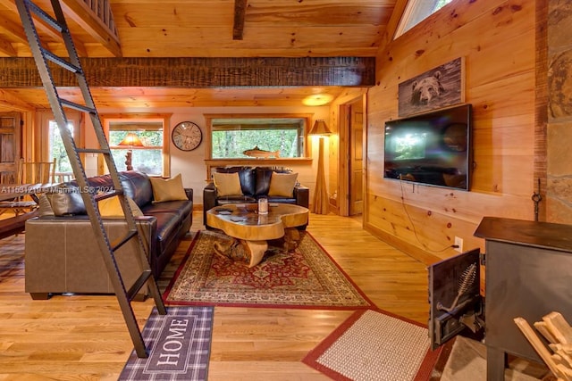 living room with light hardwood / wood-style flooring, plenty of natural light, and wooden walls