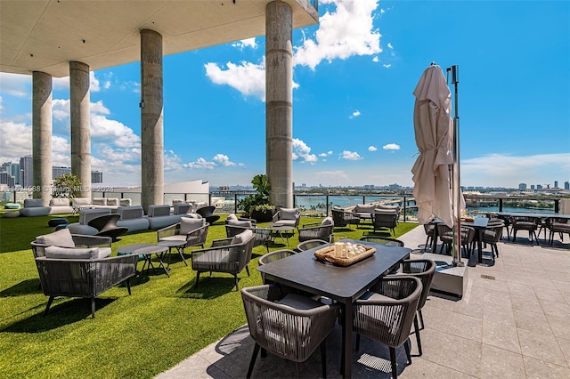 view of terrace with a water view and an outdoor living space