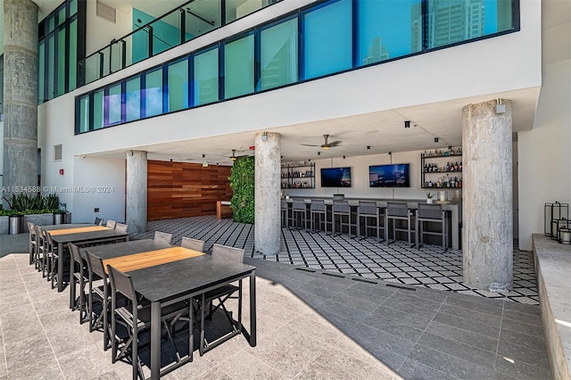 view of patio / terrace with a bar, an outdoor kitchen, and ceiling fan