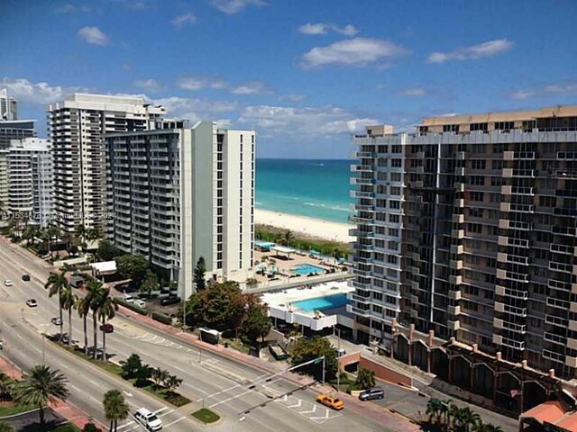 view of building exterior with a beach view and a water view