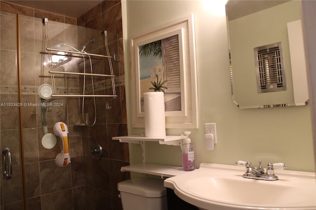 bathroom with toilet, walk in shower, and sink