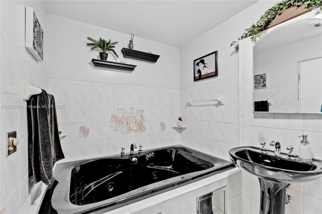 bathroom with a relaxing tiled tub and tile walls